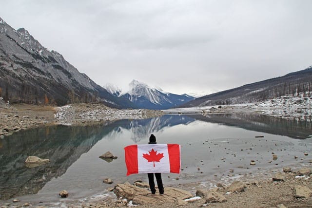Chica con bandera de canadá en un lago